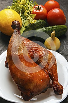 Poultry meat roasted on a grill and fresh organic vegetables on a black background. Agriculture food