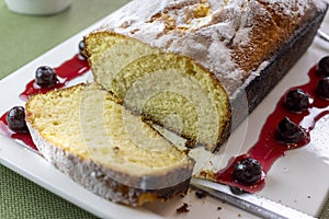 Pound Cake Loaf With Citric Sugar and Red Cherries In Syrup on a Rectangular Ceramic Plate