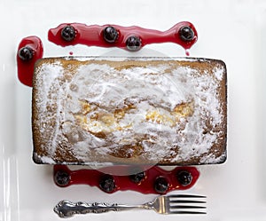 Pound Cake Loaf With Citric Sugar and Red Cherries In Syrup on a Rectangular Ceramic Plate