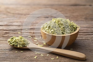 Pounded Unripe Rice, Green Rice Thai Style, for making Thai desserts in wooden bowl Khao Mao