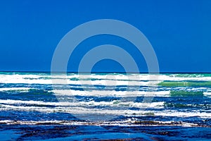 Pounding surf rolling into Bethels Beach. Auckland, New Zealand