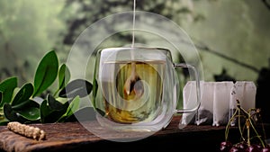 Pour black tea bags into a glass. Close-up 4k video shooting, dark background