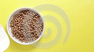 Pour cat food into a bowl, top view. Pet food