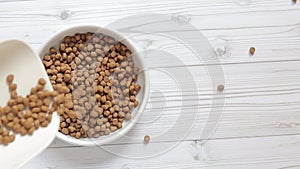 Pour cat food into a bowl, top view. Pet food