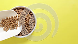 Pour cat food into a bowl, top view. Pet food