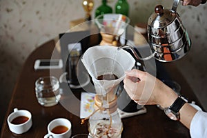 Pour coffee from the drip kettle into the paper filter