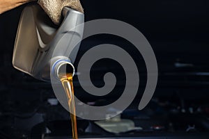 Pour engine oil from the lubricant bottle. Engine background, oil change shop engine service industry