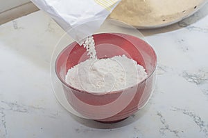 Pour flour from a bag into a bowl