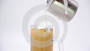 Pour the frothed cream and fresh milk into an iced coffee mug.