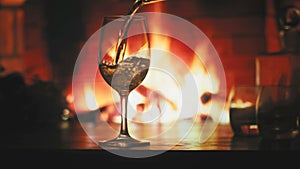 Pour a glass of white wine in front of a fireplace