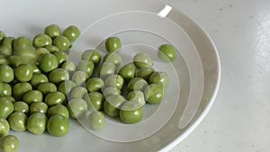 Pour green peas intermittently and the second time they pop out of the plate.