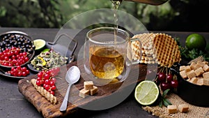 Pour herbal tea from the teapot. 4k video shooting, top view on dark background