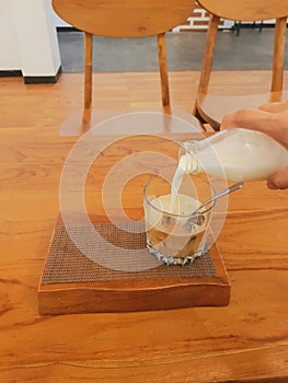 Pour hot milk on coffee ice cubes