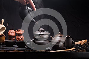 Pour hot water with a small Chinese teapot. Brewing green tea in China