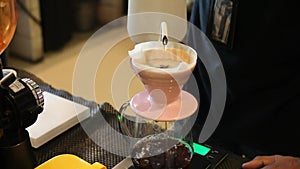 Pour hot water from the teapot into the coffee in a drip V60 until it is full