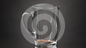 Pour instant coffee into a glass mug. Slow motion