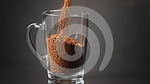 Pour instant coffee into a glass mug. Slow motion