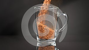 Pour instant coffee into a glass mug. Slow motion