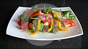 Pour olive oil over fresh vegetable salad