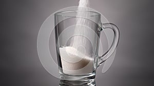 Pour sugar into a glass mug. Slow motion