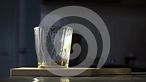 Pour two teaspoons of tea into a glass.