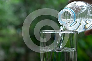 Pour water in the glass under green background