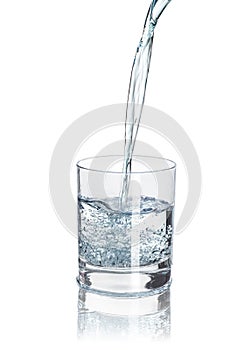 Pour water into the half-full glass with reflection isolated on