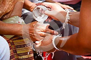 Pour water on the hands of revered elders and ask