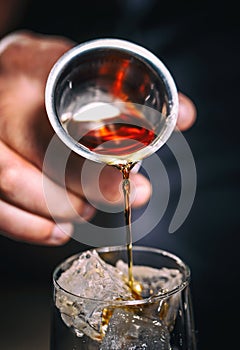 Pouring alcohol from a jigger