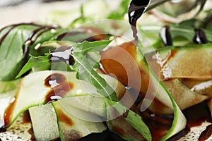 Pouring balsamic vinegar onto vegetable salad