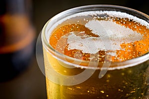 Pouring beer with bubble froth in glass for background