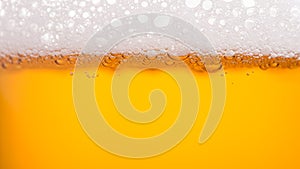 Pouring beer with bubble froth in glass for background