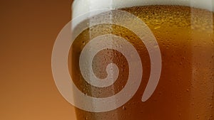 Pouring beer in glass. Cold Glass of beer close up with froth, rotation.