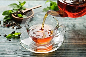 Pouring black tea into glass cup