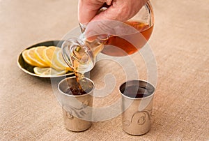 Pouring brandy into the silver drinking vessels
