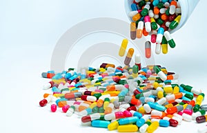 Pouring capsule pills from plastic drug bottle to white table. Pile of colorful capsule pills. Pharmaceutical industry. Healthcare