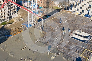 Pouring cement on the floors of residential multi-story building under construction using a concrete pump truck with high boom to