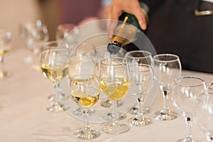 Pouring champagne in flutes standing on table