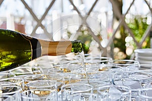 Pouring champagne in flutes standing on table