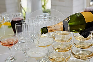 Pouring champagne in flutes standing on table