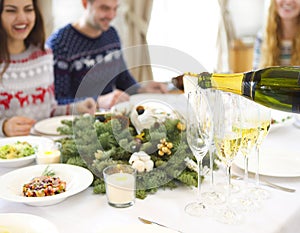 Pouring champagne into a glasses standing on table