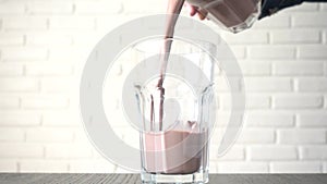 Pouring chocolate milk in to a glass