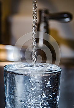 Pouring Clean safe drinking water from tap pipe home