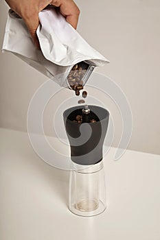 Pouring coffee beans into grinder