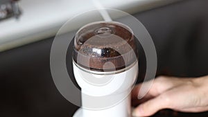 Pouring coffee beans to a coffee grinder