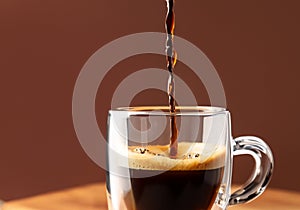 Pouring coffee in glass cup