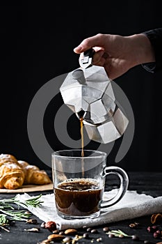 Pouring coffee from an italian percolator, shot in low key