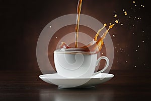 Pouring coffee into porcelain cup on brown background