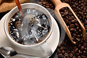 Pouring coffee with smoke on a cup and coffee beans