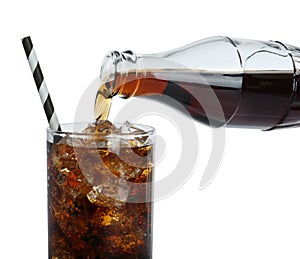 Pouring cola from bottle into glass with ice cubes on white background, closeup. Refreshing soda water